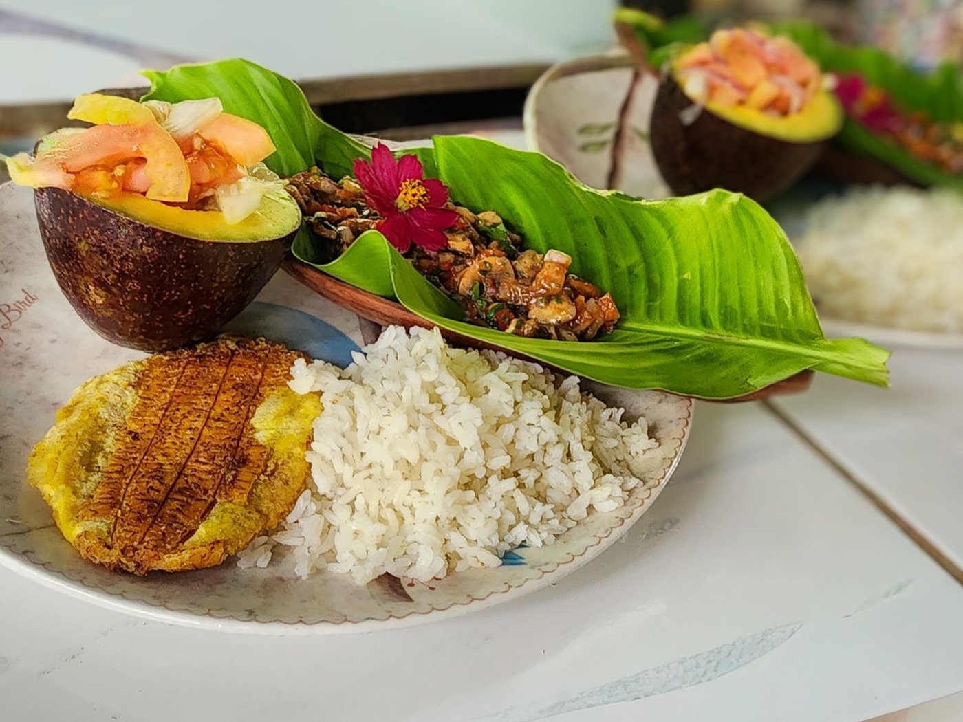 Almuerzo de finca cerca de Buga: patacón, arroz, medio aguacate relleno y un guiso servido sobre hoja de plátano
